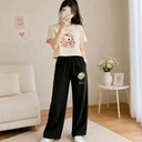 A cream crop top with a cartoon cat graphic is paired with Daisy - printed black wide - leg trousers