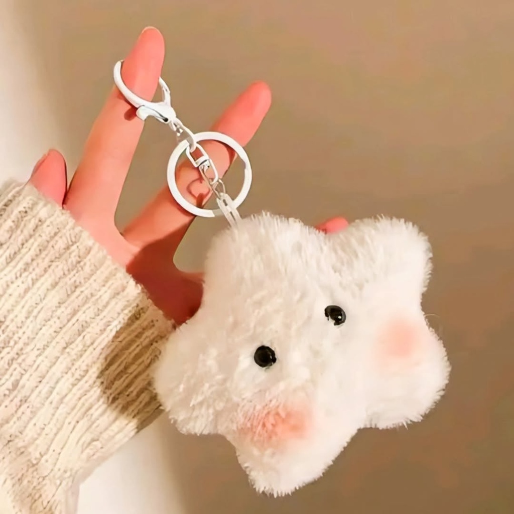 A cute, fluffy white star plush keychain with pink blushed cheeks hangs